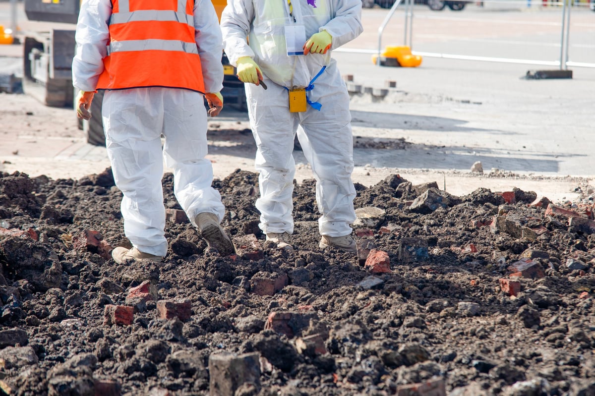 Workers in safety gear inspecting a construction site